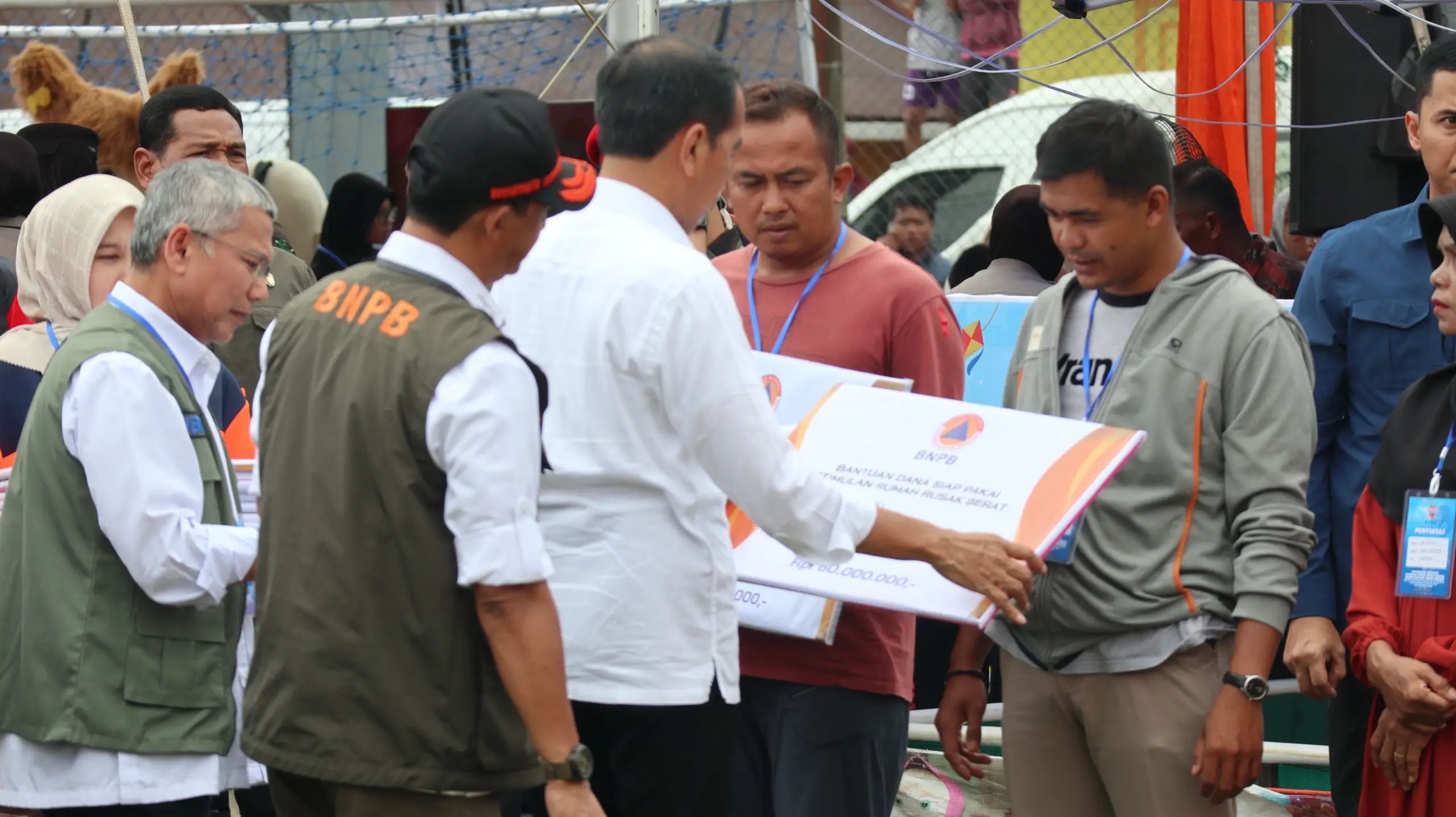 Kepala BNPB Letjen TNI Suharyanto, S.Sos., M.M., (rompi hijau dengan topi hitam) mendampingi Presiden Ir. Joko Widodo memberikan secara simbolis bantuan kepada masyarakat terdampak banjir lahar hujan Gunungapi Marapi di Pos Lapangan Batu Taba Kabupaten Agam, Sumatera Barat pada Selasa (21/5).